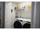 Laundry room with front loading Whirlpool washer and dryer and wire shelving at 18 Larch Radl, Ocala, FL 34480