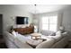 Bright living room featuring a large sectional sofa, wooden cabinet and stylish decor at 18 Larch Radl, Ocala, FL 34480