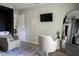 Bright salon room featuring a macrame wall hanging, TV, styling chair, and shampoo bowl at 18 Larch Radl, Ocala, FL 34480
