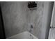 Tiled shower with mounted shelving stocked with various soaps and shampoos at 18 Larch Radl, Ocala, FL 34480
