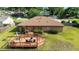 Aerial view showcases a wooden deck with dining and lounge furniture in a spacious fenced-in backyard at 2045 Se 32Nd St, Ocala, FL 34471
