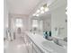 Bright bathroom featuring dual sinks, a large mirror, and a shower/tub combination with white tile at 2045 Se 32Nd St, Ocala, FL 34471