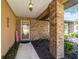 Inviting porch with brick columns, a welcome sign, and lush greenery lining the walkway to the glass front door at 2045 Se 32Nd St, Ocala, FL 34471