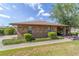 A brick house features a well-kept lawn and mature trees with an inviting sidewalk that leads to the front door at 2045 Se 32Nd St, Ocala, FL 34471