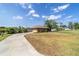 A well-kept lawn with mature trees, and an inviting driveway leads to a charming brick home with a brown roof at 2045 Se 32Nd St, Ocala, FL 34471
