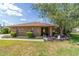Charming brick home with well-manicured lawn, bushes, and a beautiful tree in the front yard on a sunny day at 2045 Se 32Nd St, Ocala, FL 34471