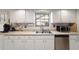 Bright kitchen features stainless steel appliances and ample white cabinets with hardware at 2045 Se 32Nd St, Ocala, FL 34471