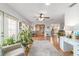 Bright living room featuring hardwood floors, white walls, a ceiling fan, and several plants near large windows at 2045 Se 32Nd St, Ocala, FL 34471