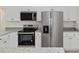 Close up of stainless steel appliances, granite countertops, and white cabinets at 24375 Nw Foxglove Ln, Dunnellon, FL 34431