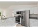 Bright kitchen features white cabinets, stainless steel appliances, and granite countertops at 24375 Nw Foxglove Ln, Dunnellon, FL 34431