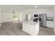 Open-concept living room and kitchen with luxury vinyl plank flooring and stainless steel appliances at 24375 Nw Foxglove Ln, Dunnellon, FL 34431
