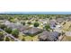 A wide aerial view of the community with many roofs and lush green trees at 4013 Ruby Run, Haines City, FL 33844