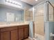 Well-lit bathroom featuring dual sinks, wood cabinetry, and glass shower stall at 4013 Ruby Run, Haines City, FL 33844