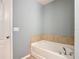 Bathroom features a pristine white tub, tile detail, and modern fixtures at 4013 Ruby Run, Haines City, FL 33844