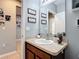 Bathroom featuring dark vanity, gray walls, and decorative wall art at 4013 Ruby Run, Haines City, FL 33844