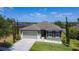 Inviting one-story home showcasing a green lawn, two-car garage, and meticulously maintained landscape at 4013 Ruby Run, Haines City, FL 33844