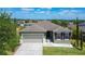 Attractive exterior view of home with a neatly kept lawn, beautiful landscaping, and attached garage at 4013 Ruby Run, Haines City, FL 33844