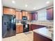Functional kitchen featuring dark wood cabinets, black appliances, and ample counter space at 4013 Ruby Run, Haines City, FL 33844
