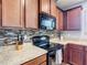 Close-up of the kitchen area shows dark wood cabinetry, mosaic tile backsplash, and black appliances at 4013 Ruby Run, Haines City, FL 33844