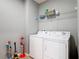 Functional laundry room equipped with a washer, dryer, and storage shelves at 4013 Ruby Run, Haines City, FL 33844