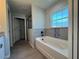 Bright bathroom features a large tub with tiled accents and natural light from a window at 4424 Sw Viola Ct, Dunnellon, FL 34431
