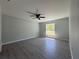Spacious bedroom with laminate flooring, ceiling fan, neutral walls, and ample natural light from the window at 4424 Sw Viola Ct, Dunnellon, FL 34431