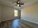Bedroom featuring a ceiling fan, light gray walls, wood-look flooring, and a window at 4424 Sw Viola Ct, Dunnellon, FL 34431