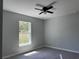Cozy bedroom with a ceiling fan, laminate flooring, neutral paint, and a bright window at 4424 Sw Viola Ct, Dunnellon, FL 34431