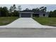 Charming single-story home with a gray exterior, attached garage, and a well-manicured lawn at 4424 Sw Viola Ct, Dunnellon, FL 34431