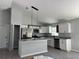 Bright kitchen featuring white cabinets, stainless steel appliances, granite countertops, and modern pendant lighting at 4424 Sw Viola Ct, Dunnellon, FL 34431