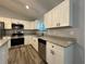 Updated kitchen features stainless appliances, gray cabinets, granite countertops and modern fixtures at 4424 Sw Viola Ct, Dunnellon, FL 34431