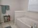 Bright bathroom featuring a large soaking tub and neutral tile flooring and decor at 4677 Nw 46Th Ave, Ocala, FL 34482