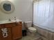 Bathroom with wooden vanity, neutral tile, and shower with decorative curtain at 4677 Nw 46Th Ave, Ocala, FL 34482