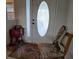 Cozy entryway with unique decor, oval window front door, and vintage-style rug adding warmth at 4677 Nw 46Th Ave, Ocala, FL 34482