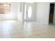 Bright living room featuring neutral tile flooring, large windows, and a white front door at 4677 Nw 46Th Ave, Ocala, FL 34482