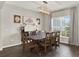 Dining area boasts modern chandelier, rustic table, and large windows creating a bright and inviting atmosphere at 4806 Nw 8Th Ter, Ocala, FL 34475