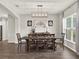 Dining area features a modern light fixture, wooden table, and large windows that flood the space with natural light at 4806 Nw 8Th Ter, Ocala, FL 34475