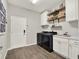Functional laundry room with modern appliances, sleek cabinets, and wood-look flooring at 4806 Nw 8Th Ter, Ocala, FL 34475