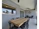 Covered patio featuring a large wood table with seating, ceiling fan, and decorative wall clock at 4806 Nw 8Th Ter, Ocala, FL 34475