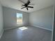 Bedroom featuring a ceiling fan, window, and light gray wood-look tile flooring at 4928 Sw Evergreen Ct, Dunnellon, FL 34431