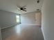 Bright bedroom featuring a ceiling fan, window, and gray wood-look tile flooring at 4928 Sw Evergreen Ct, Dunnellon, FL 34431