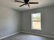Bedroom with a ceiling fan, wood-look tile flooring, neutral walls, and a window overlooking the yard at 4928 Sw Evergreen Ct, Dunnellon, FL 34431