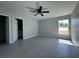 Spacious bedroom boasts a ceiling fan, light gray walls, and a window with natural light at 4928 Sw Evergreen Ct, Dunnellon, FL 34431
