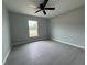 Bedroom featuring a ceiling fan, window, and light gray wood-look tile flooring at 4928 Sw Evergreen Ct, Dunnellon, FL 34431