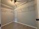 Walk-in closet with built-in shelving and light-colored wood-look tile flooring at 4928 Sw Evergreen Ct, Dunnellon, FL 34431