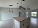 Kitchen island with pendant lighting, granite countertops and an open concept living room and front door at 4928 Sw Evergreen Ct, Dunnellon, FL 34431