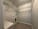 A clean, functional laundry room with white shelving and modern tile flooring at 4928 Sw Evergreen Ct, Dunnellon, FL 34431