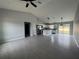 An open-concept living room and kitchen with modern gray floors and ample natural light at 4928 Sw Evergreen Ct, Dunnellon, FL 34431