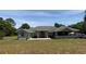 Charming single-story home featuring a covered porch, well-manicured lawn, and an inviting red front door at 4981 Ne 110Th Street Ne St, Anthony, FL 32617