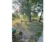 Spacious backyard with mature trees, partially fenced, and a garden area ready for planting at 5365 Sw 111Th Lane Rd, Ocala, FL 34476